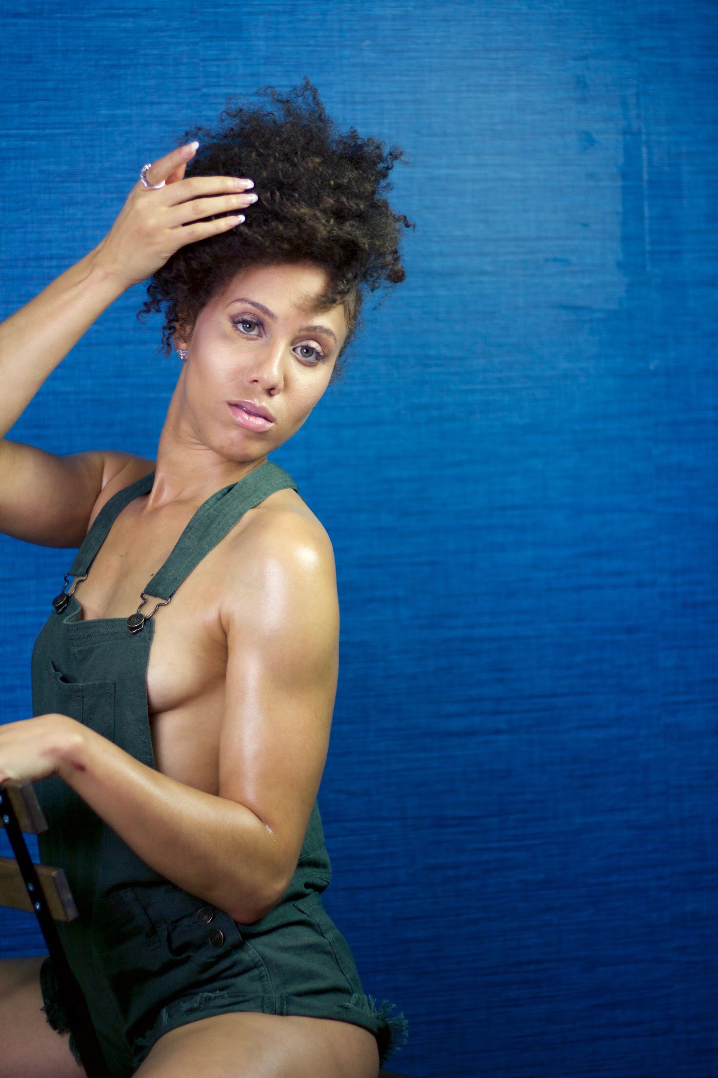 IREIGN in dark overalls against a deep blue wall