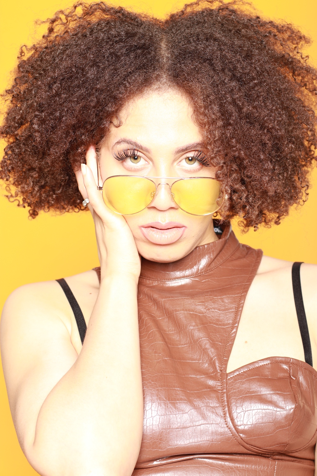 IREIGN in yellow-tinted glasses and a leather top on yellow